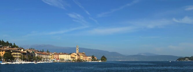 Trip Polen beliebte Urlaubsziele am Gardasee -  Mit einer Fläche von 370 km² ist der Gardasee der größte See Italiens. Es liegt am Fuße der Alpen und erstreckt sich über drei Staaten: Lombardei, Venetien und Trentino. Die maximale Tiefe des Sees beträgt 346 m, er hat eine längliche Form und sein nördliches Ende ist sehr schmal. Dort ist der See von den Bergen der Gruppo di Baldo umgeben. Du trittst aus deinem gemütlichen Hotelzimmer und es begrüßt dich die warme italienische Sonne. Du blickst auf den atemberaubenden Gardasee, der in zahlreichen Blautönen schimmert - von tiefem Dunkelblau bis zu funkelndem Türkis. Majestätische Berge umgeben dich, während die Brise sanft deine Haut streichelt und der Duft von blühenden Zitronenbäumen deine Nase kitzelt. Du schlenderst die malerischen, engen Gassen entlang, vorbei an farbenfrohen, blumengeschmückten Häusern. Vereinzelt unterbricht das fröhliche Lachen der Einheimischen die friedvolle Stille. Du fühlst dich wie in einem Traum, der nicht enden will. Jeder Schritt führt dich zu neuen Entdeckungen und Abenteuern. Du probierst die köstliche italienische Küche mit ihren frischen Zutaten und verführerischen Aromen. Die Sonne geht langsam unter und taucht den Himmel in ein leuchtendes Orange-rot - ein spektakulärer Anblick.